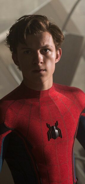 Tom Holland in Spider Man suit looking serious in a close up shot