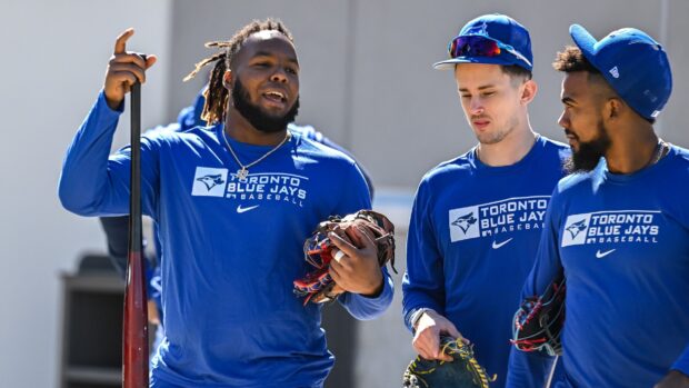 Toronto Blue Jays players chatting during practice session in blue uniform