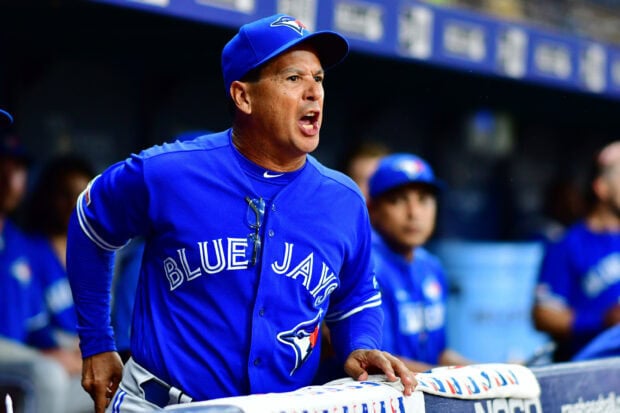 A Toronto Blue Jays coach passionately shouting during a game in a blue jersey