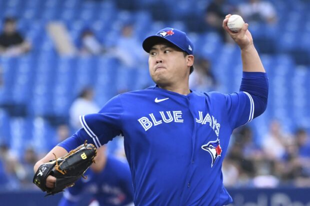 A Toronto Blue Jays player pitching a baseball during the game in a stadium