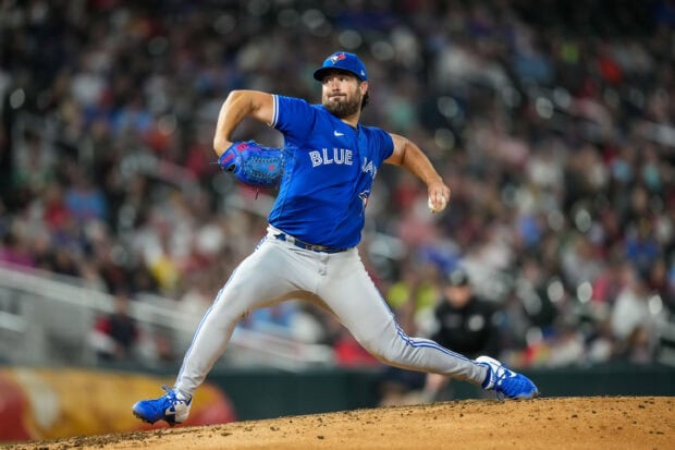 A Toronto Blue Jays player pitching the ball in a baseball game on the mound