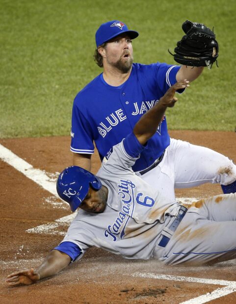 A Toronto Blue Jays player catching a ball during a baseball game with intense action
