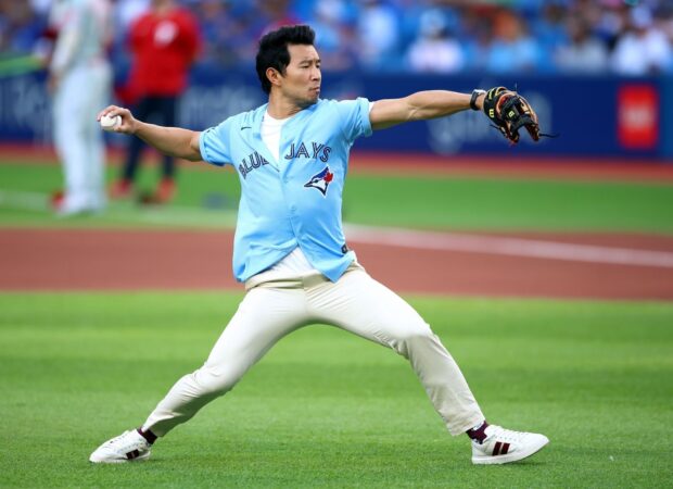 A Toronto Blue Jays player pitching a baseball during a game on the field