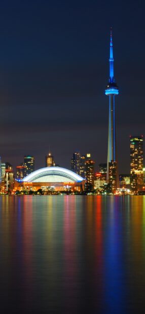 Night view of Toronto skyline with the CN Tower and city lights reflecting on water
