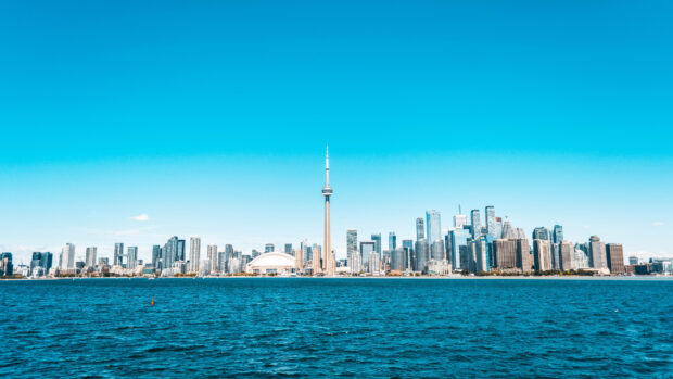 Clear view of Toronto skyline with the lake in front and blue sky above
