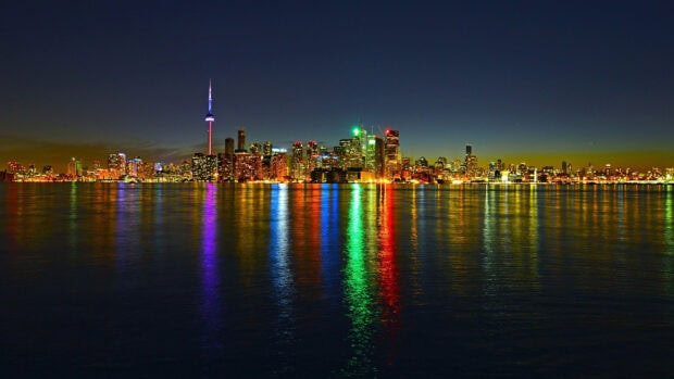 Toronto skyline with colorful lights reflecting on the water at night