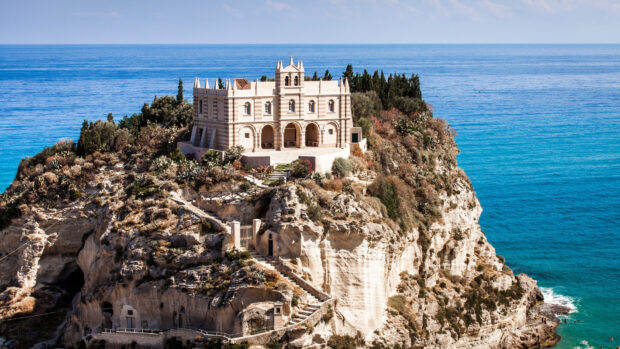Historic building on rocky cliff in Tropea surrounded by Mediterranean Sea