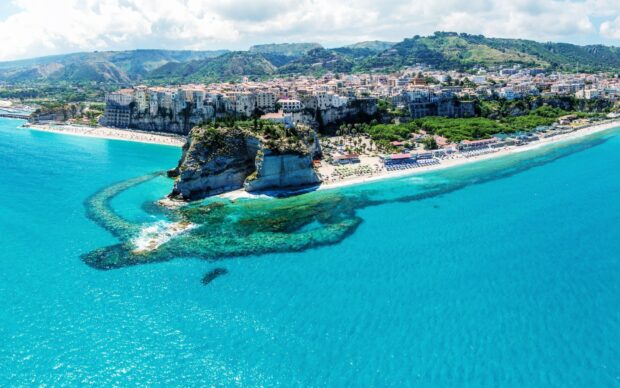 Stunning Tropea coastline with cliffside town and turquoise sea in bright sunlight