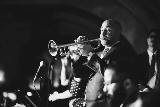 A musician playing trumpet in a live jazz performance setting