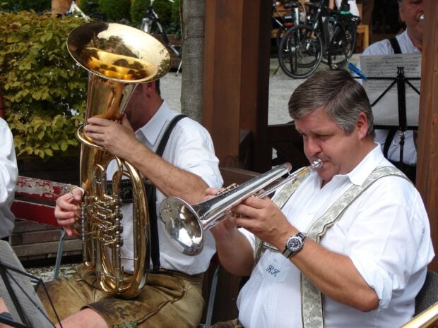 A man playing trumpet intensely during an outdoor musical performance