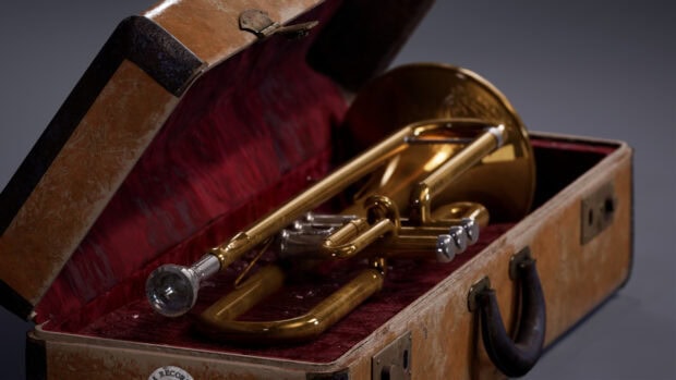 Vintage trumpet resting in an open case with red velvet lining