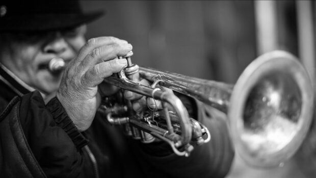 Close up of hands playing a trumpet with detailed instrument parts visible