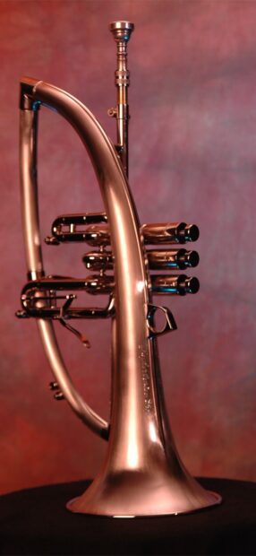 A close up of a brass trumpet with detailed valves and curved tubing