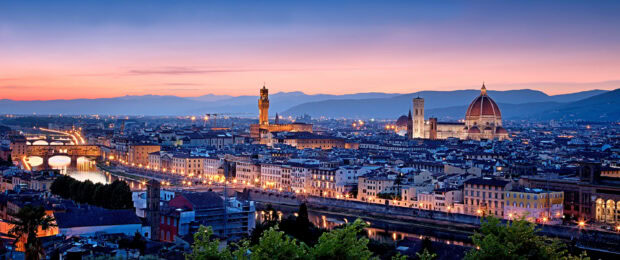 Beautiful cityscape of Tuscany with historic buildings and a river at sunset