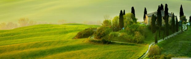 A serene Tuscany landscape with green hills and a rustic farmhouse surrounded by cypress trees