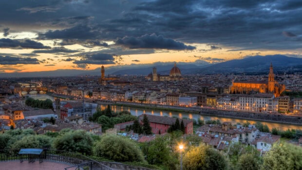 Panoramic view of tuscany cityscape at sunset with river and historic buildings