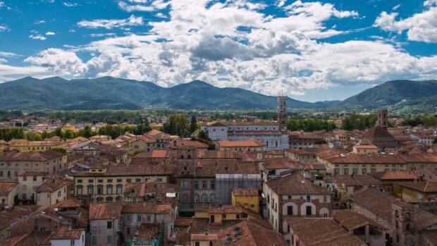 A panoramic view of Tuscany city rooftops with mountains in the background
