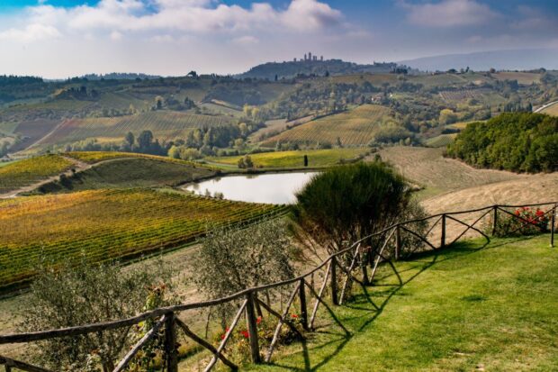 Rolling hills of Tuscany with vineyards and a small lake in high definition quality