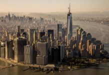 Aerial view of usa skyline with prominent skyscrapers along the waterfront in golden sunlight