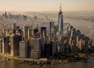 Aerial view of usa skyline with prominent skyscrapers along the waterfront in golden sunlight