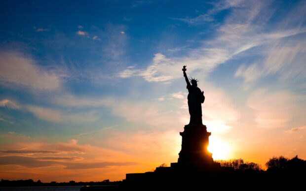 Silhouette of the Statue of Liberty at sunset with a colorful sky in the usa