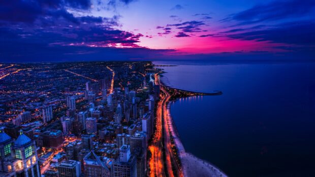 Cityscape of usa at night with glowing streetlights along the coastline and colorful sunset sky