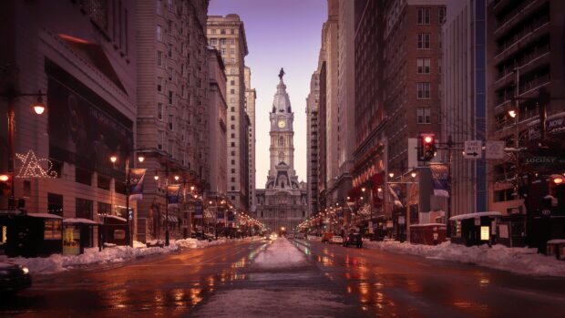 Historic Philadelphia city hall with snow and street lights in view during sunset