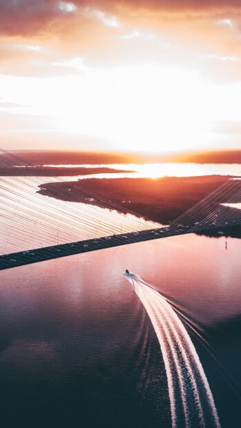 A boat speeding across the river near the usa during a bright sunset