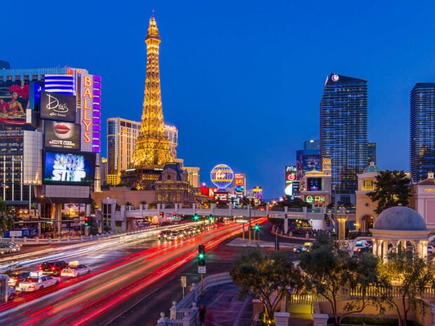 Night view of a busy street with the Eiffel Tower replica in Las Vegas Usa