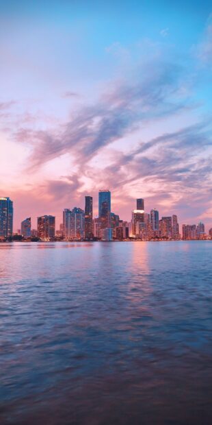 Beautiful usa city skyline during sunset with colorful sky and calm water reflection