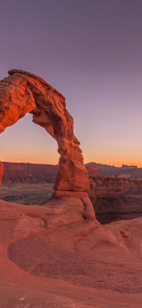 Natural rock formation in Utah during sunset with clear sky and desert landscape