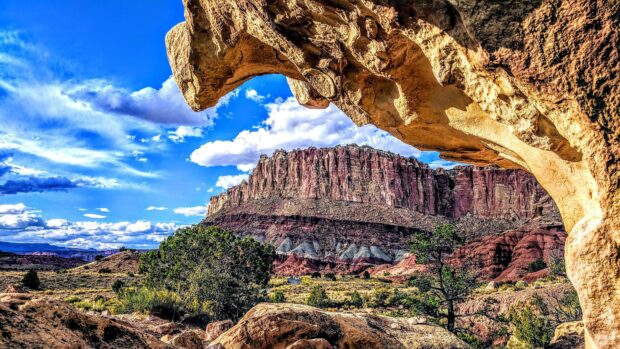 Red rock formations and desert landscape of Utah seen through a natural rock archway