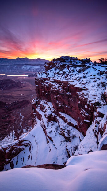 Snow covered Utah cliffs at sunset with a colorful sky
