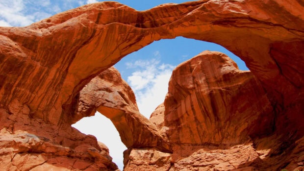 Natural red rock formation with arches under a blue sky in Utah
