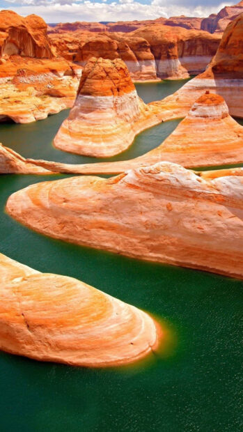 Majestic Utah rock formations rising from green water in a natural landscape