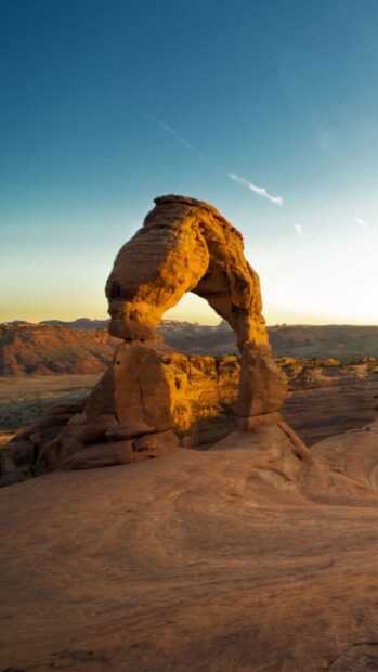 Natural Utah arch formation at sunset on a desert landscape