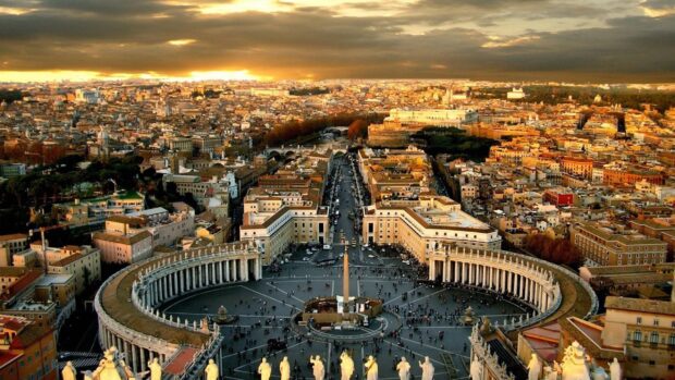 A panoramic view of Vatican City showing St Peters Square with its iconic colonnades at sunset