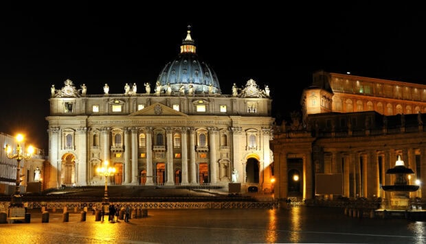 Night view of Vatican City with illuminated Saint Peter Basilica and surrounding structures