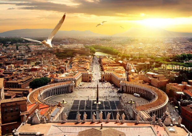 A bird flying over Vatican City in the golden sunlight with panoramic view