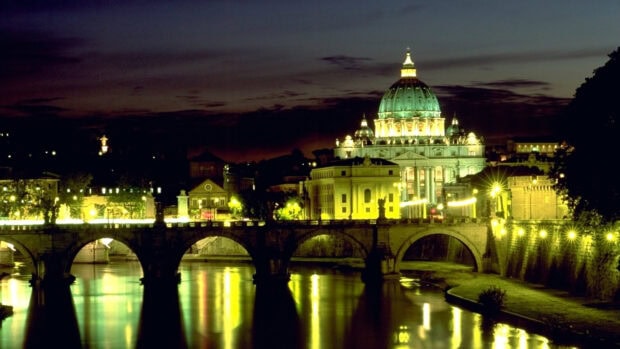 Stunning Vatican City architecture illuminated at night with river reflections and clear sky