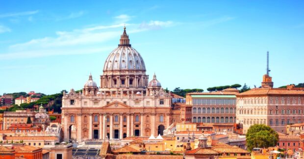 The historic Vatican City architecture with the famous dome under a clear blue sky