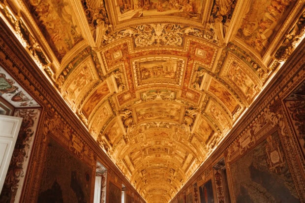 Intricate ceilings with detailed Vatican City artwork and decorations in golden tones