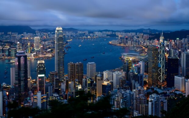 Night cityscape view from Victoria Peak with illuminated skyscrapers and harbor reflection
