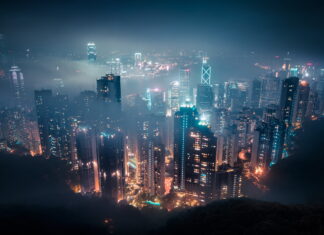 A stunning view of Victoria Peak cityscape with high rise buildings and glowing lights at night