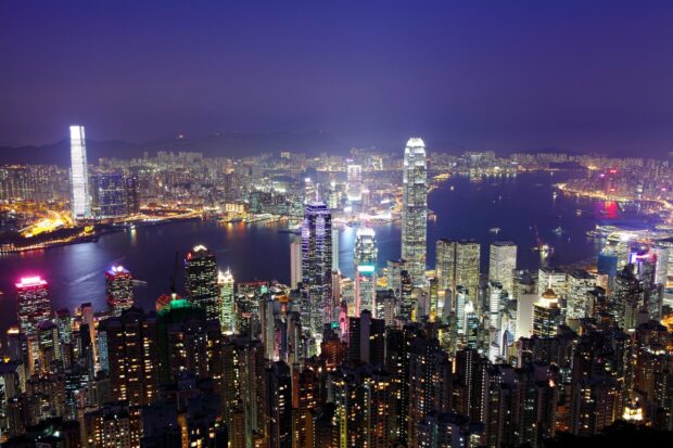 Nighttime cityscape of Victoria Peak with glowing skyscrapers and harbor view