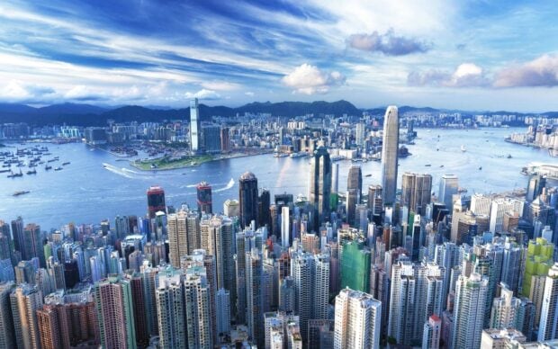 Stunning Victoria Peak cityscape with skyscrapers and harbor under blue sky