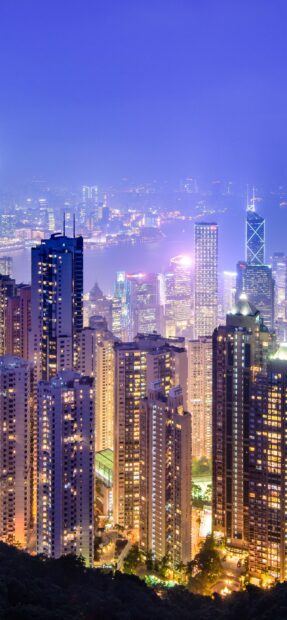 Night view of Victoria Peak cityscape with bright lit buildings and harbor lights