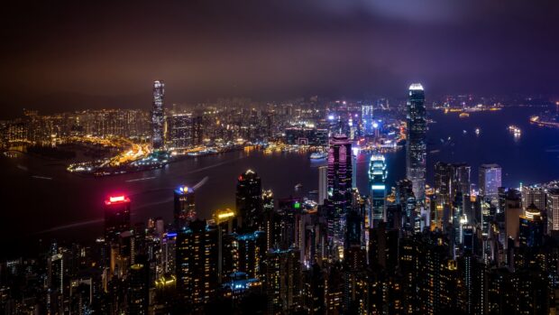 Nighttime cityscape with Victoria Peak skyline illuminated by colorful lights