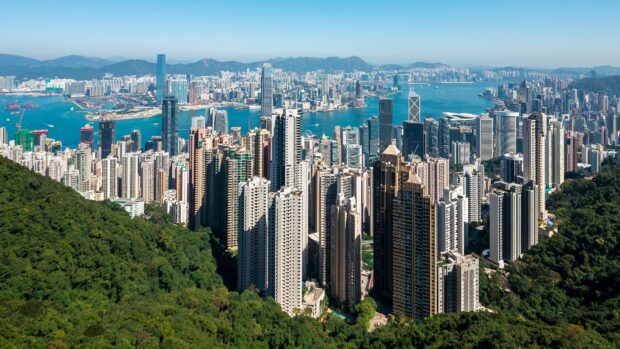 Panoramic view of Victoria Peak and Hong Kong cityscape with lush greenery and skyscrapers