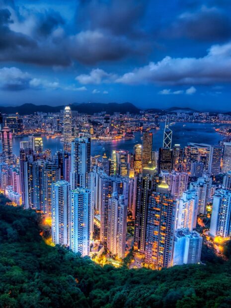 Night cityscape with Victoria Peak skyline and illuminated buildings in Hong Kong
